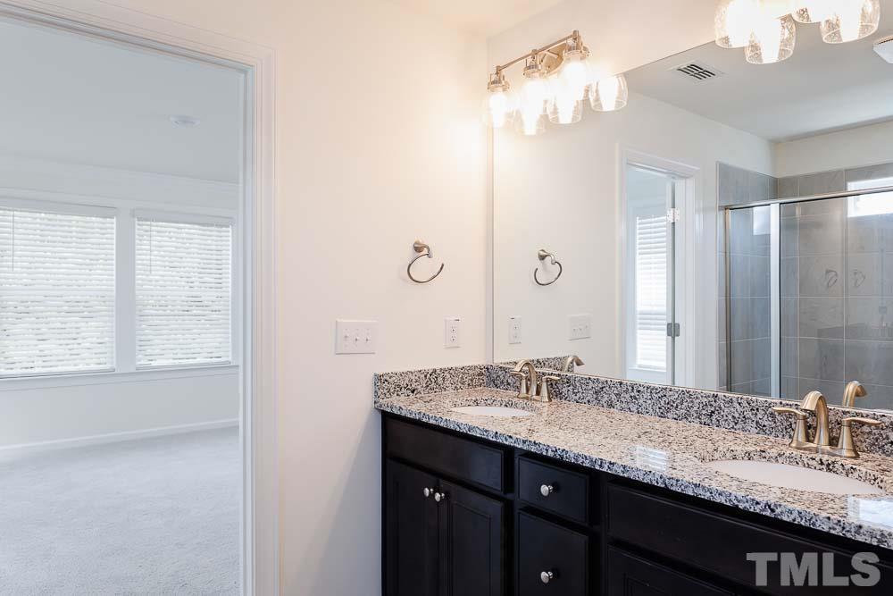 6940 Leesville Road, Unit 10 Raleigh, NC 27613 - Photo 28 of 38 a bathroom with a granite countertop sink and a mirror