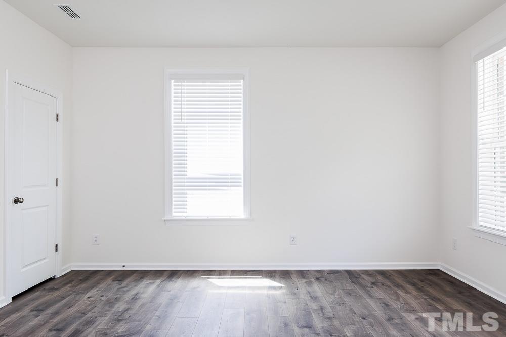 6940 Leesville Road, Unit 10 Raleigh, NC 27613 - Photo 33 of 38 an empty room with wooden floor and windows
