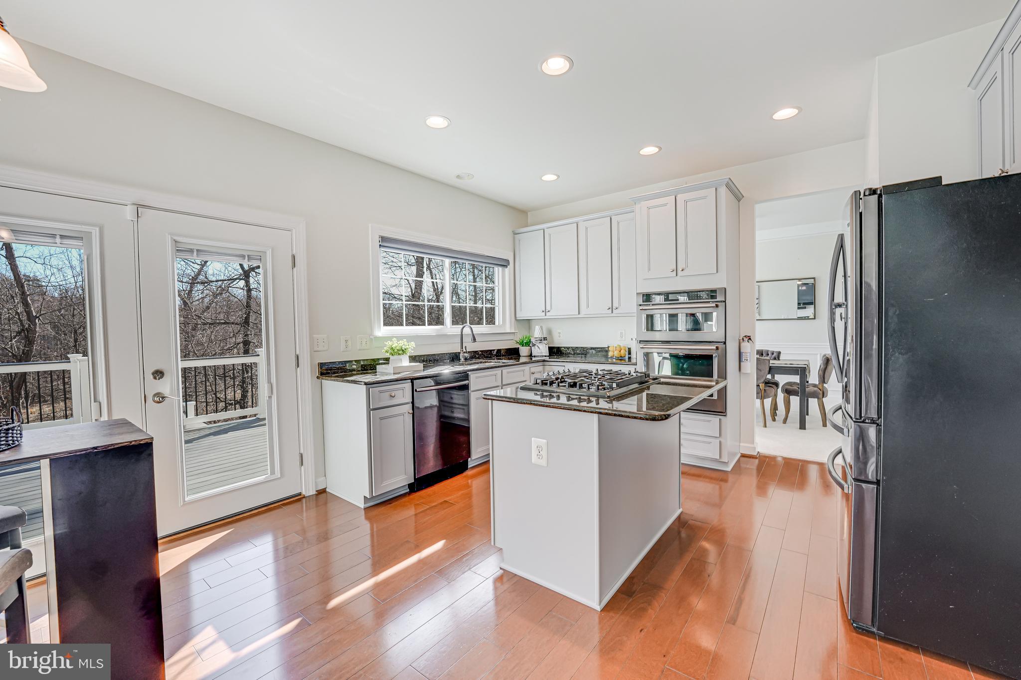 17583 Summer Duck Drive Dumfries, VA 22026 - Photo 11 of 49 a kitchen with stainless steel appliances granite countertop a stove top oven a refrigerator a sink and a refrigerator