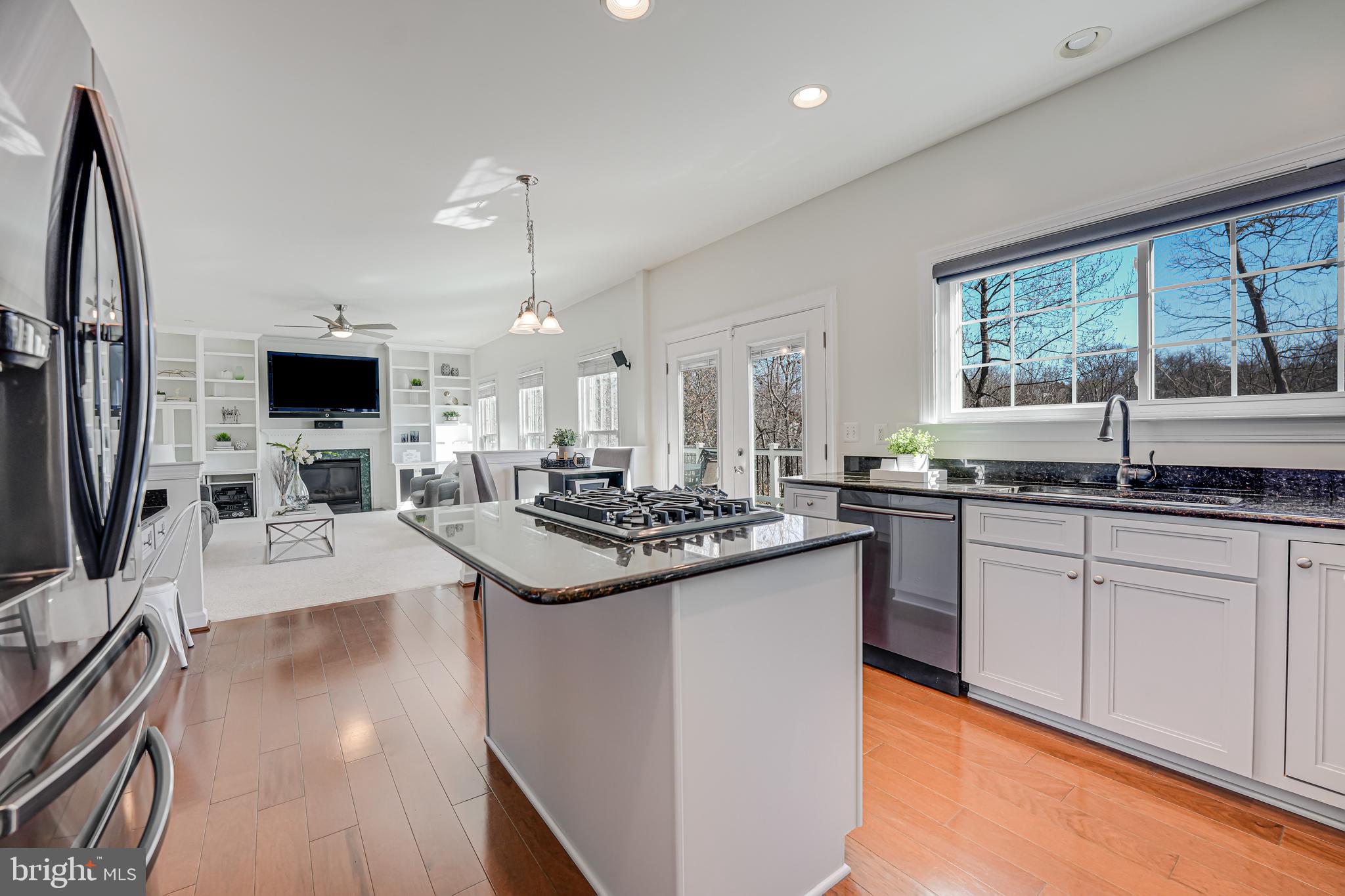 17583 Summer Duck Drive Dumfries, VA 22026 - Photo 14 of 49 a kitchen with stainless steel appliances a stove top oven a sink a dining table and chairs