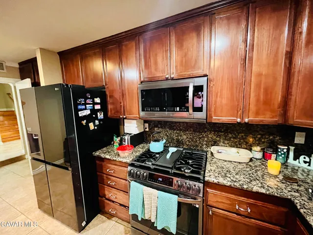 a kitchen with granite countertop stainless steel appliances and wooden cabinets