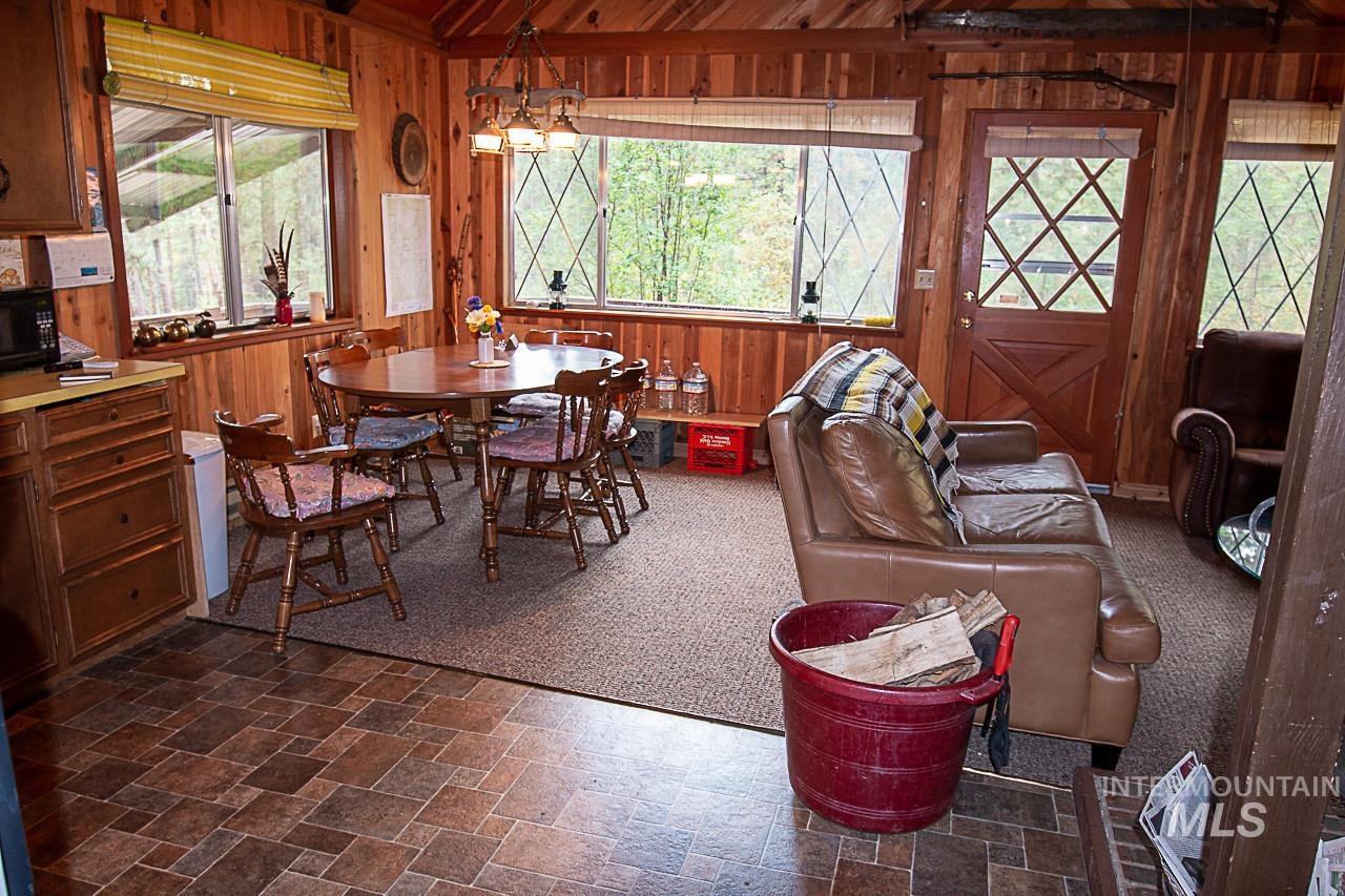 225 Mesplie Road Placerville, ID 83666 - Photo 13 of 39 Dining space with wooden walls, healthy amount of natural light, and dark stone finish floors