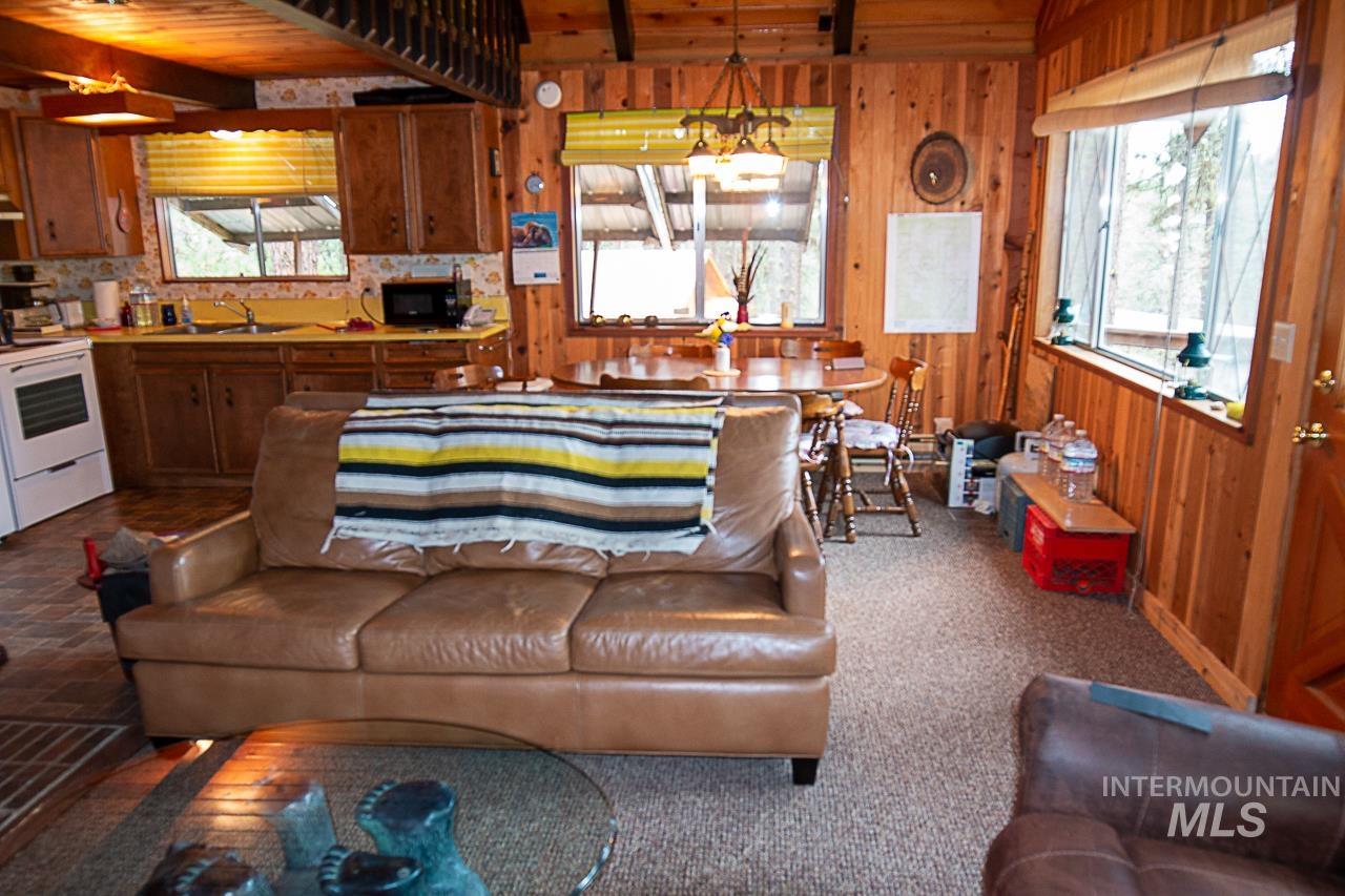 225 Mesplie Road Placerville, ID 83666 - Photo 17 of 39 Living area with healthy amount of natural light, wooden walls, and a wood ceiling with exposed beams