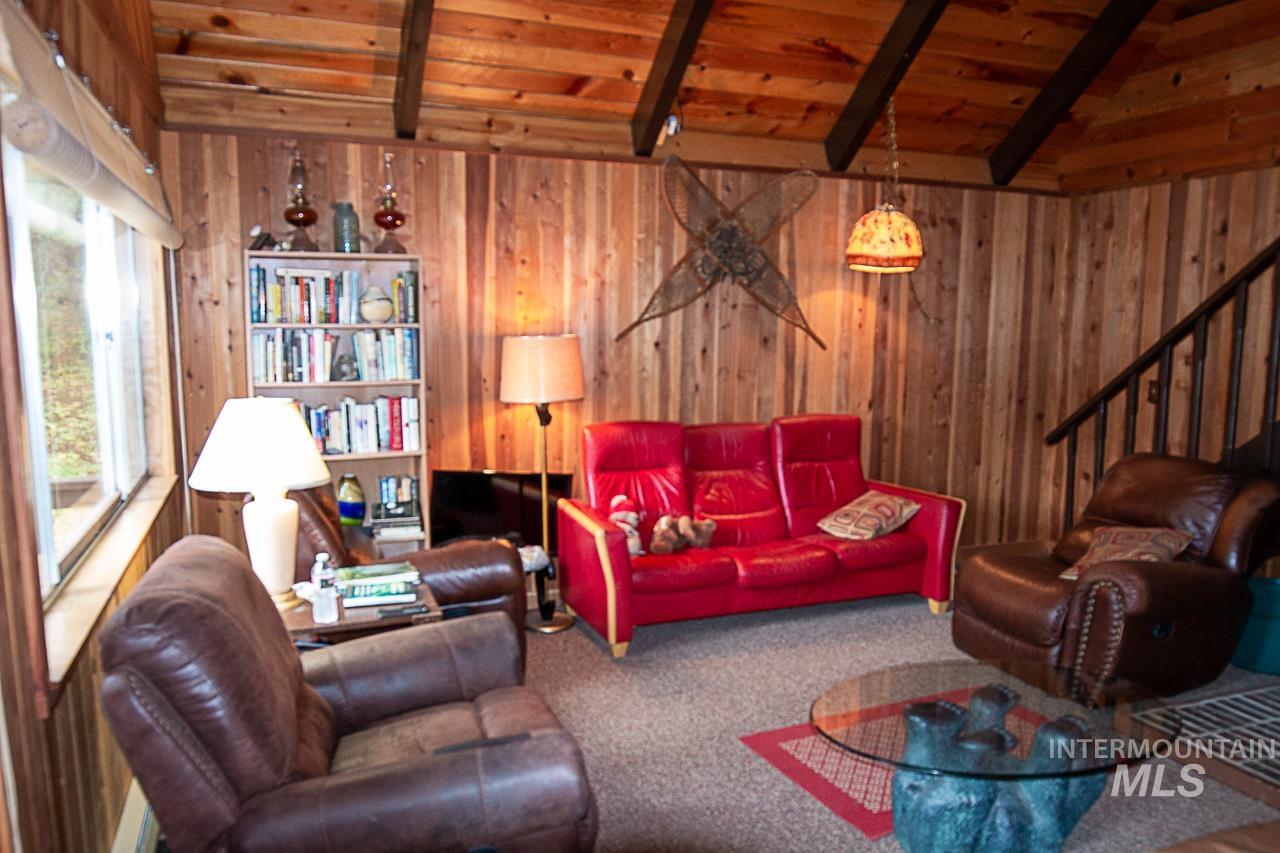 225 Mesplie Road Placerville, ID 83666 - Photo 20 of 39 Living area featuring carpet floors, wooden ceiling, stairway, and wood walls