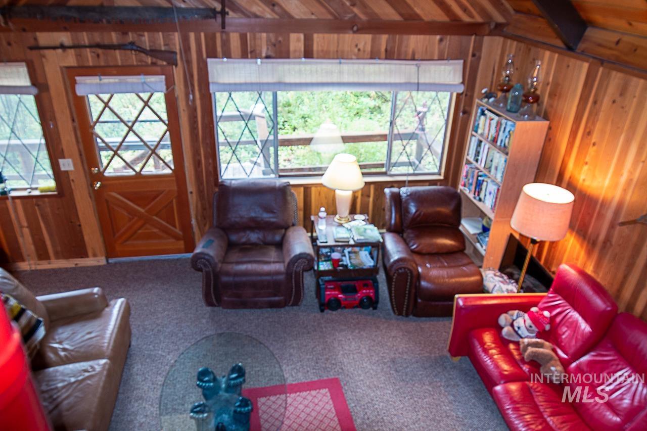 225 Mesplie Road Placerville, ID 83666 - Photo 27 of 39 Carpeted living area with wood walls