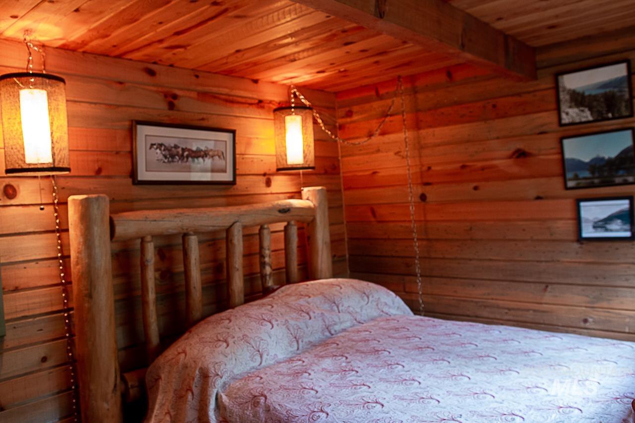 225 Mesplie Road Placerville, ID 83666 - Photo 29 of 39 Bedroom with wooden ceiling and wooden walls