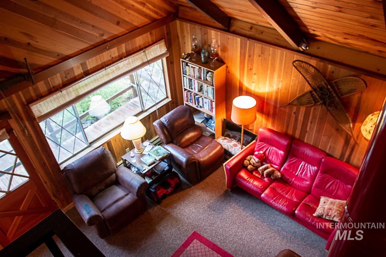 225 Mesplie Road Placerville, ID 83666 - Photo 32 of 39 Carpeted living area featuring wood walls and wooden ceiling