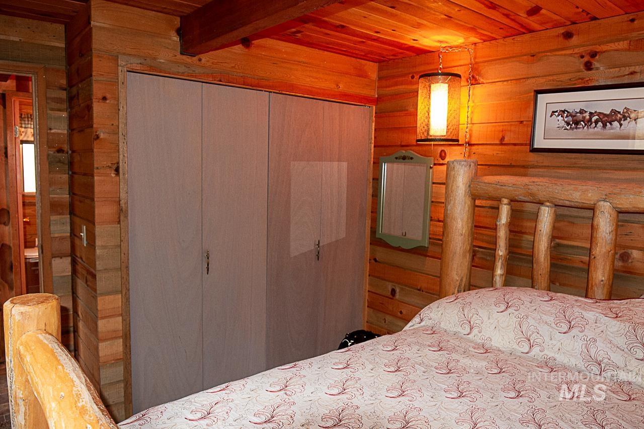 225 Mesplie Road Placerville, ID 83666 - Photo 10 of 39 Bedroom with a wooden ceiling with exposed beams, a closet, and wooden walls