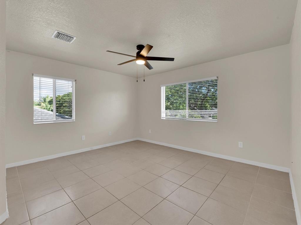 308 Northwest 17th Terrace Pompano Beach, FL 33069 - Photo 2 of 43 an empty room with windows and ceiling fan
