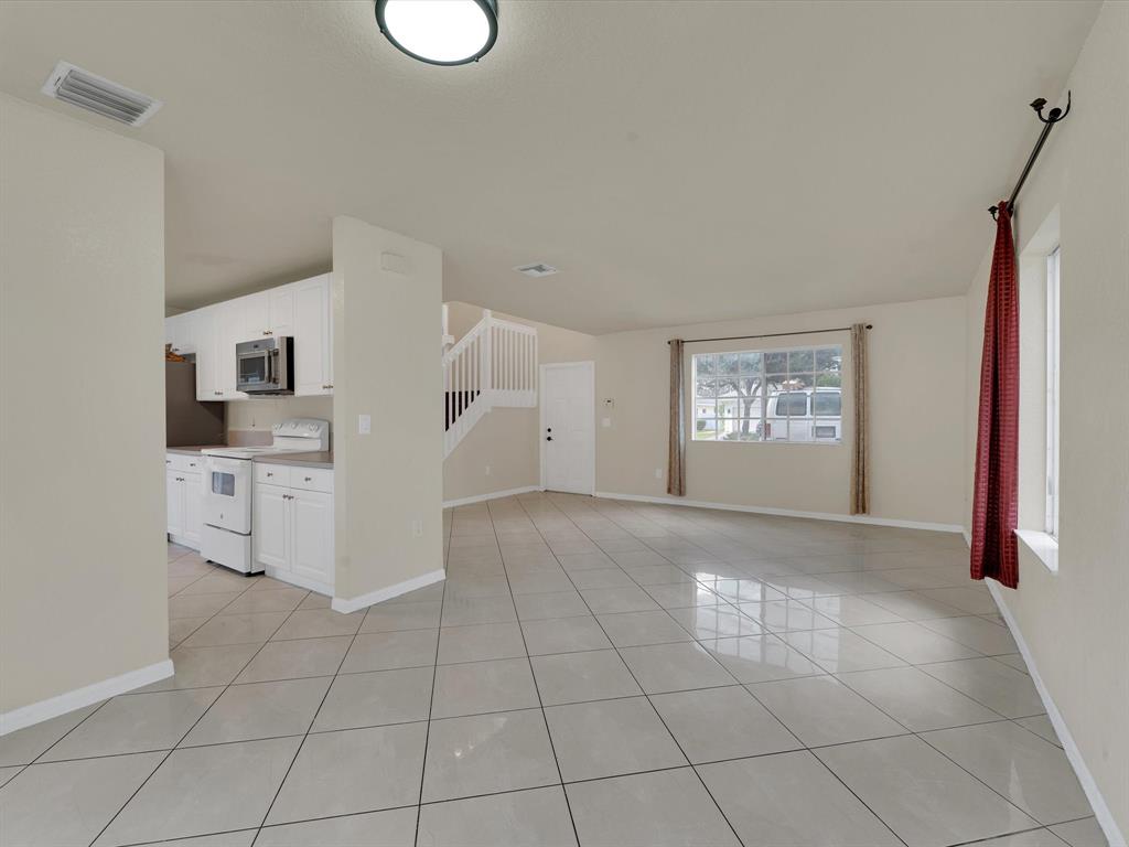 308 Northwest 17th Terrace Pompano Beach, FL 33069 - Photo 24 of 43 a view of a kitchen with white cabinets and wooden floor