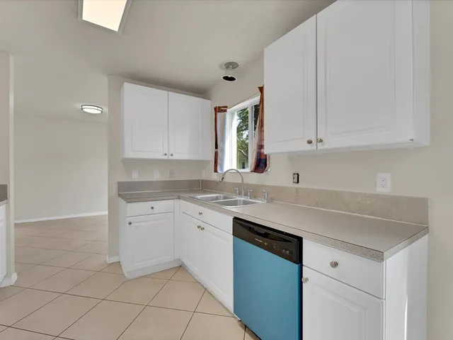 a kitchen with stainless steel appliances granite countertop a sink and dishwasher a stove with white cabinets