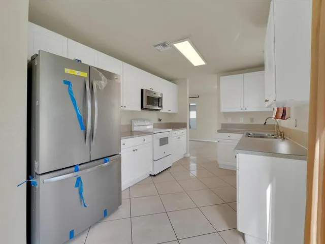 a kitchen with stainless steel appliances a refrigerator sink and microwave