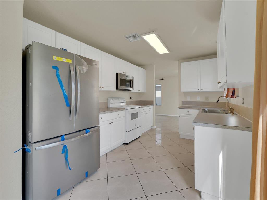 308 Northwest 17th Terrace Pompano Beach, FL 33069 - Photo 29 of 43 a kitchen with stainless steel appliances a refrigerator sink and microwave