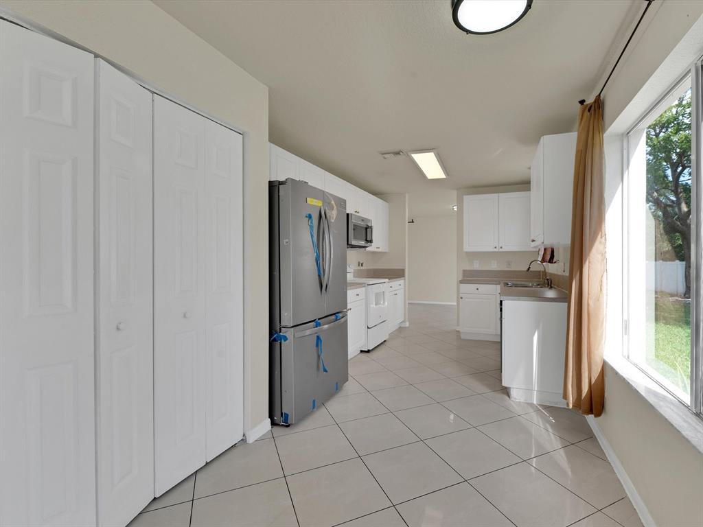 308 Northwest 17th Terrace Pompano Beach, FL 33069 - Photo 30 of 43 a kitchen with white cabinets and white appliances