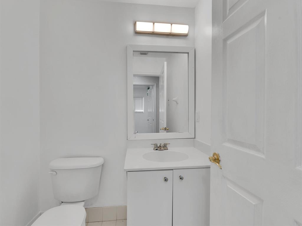 308 Northwest 17th Terrace Pompano Beach, FL 33069 - Photo 37 of 43 a bathroom with a sink a toilet and a mirror