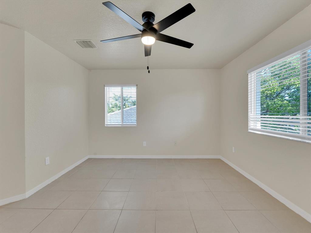 308 Northwest 17th Terrace Pompano Beach, FL 33069 - Photo 5 of 43 en empty room with windows and ceiling fan
