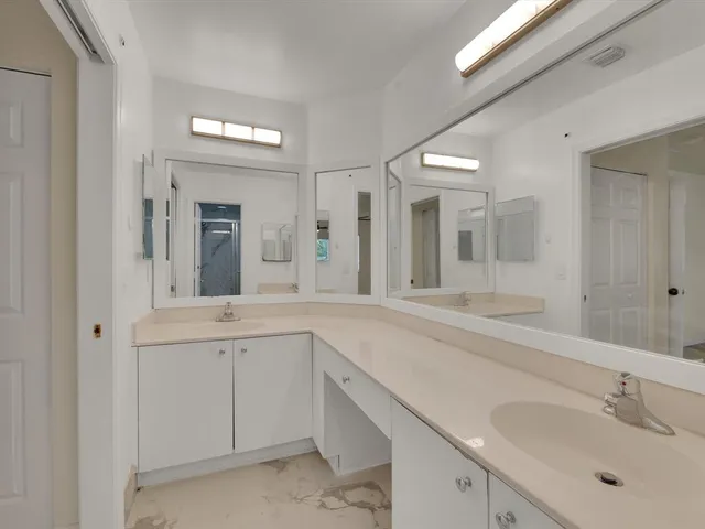 a spacious bathroom with a sink and mirror