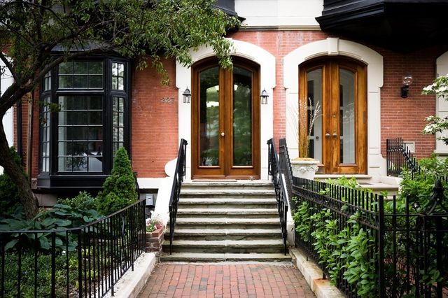 a view of a house with large windows and flower plants