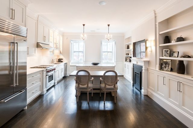 a kitchen with stainless steel appliances granite countertop a stove a sink dishwasher a refrigerator and dining table with wooden floor