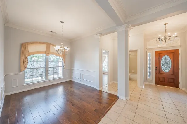 an empty room with wooden floor cabinet and windows