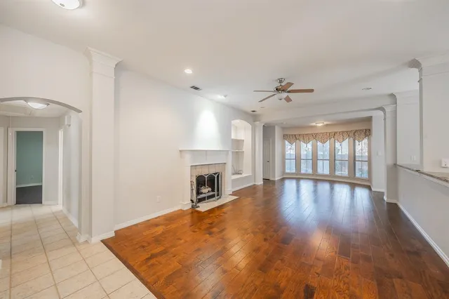 a view of empty room with wooden floor and fireplace