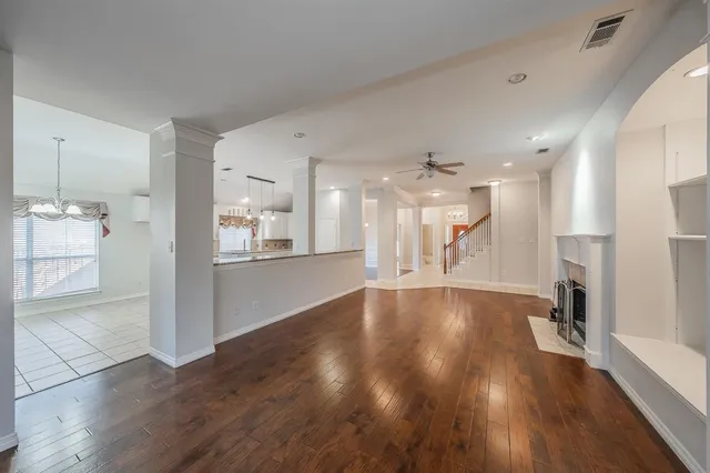 a view of a big room with wooden floor and a kitchen