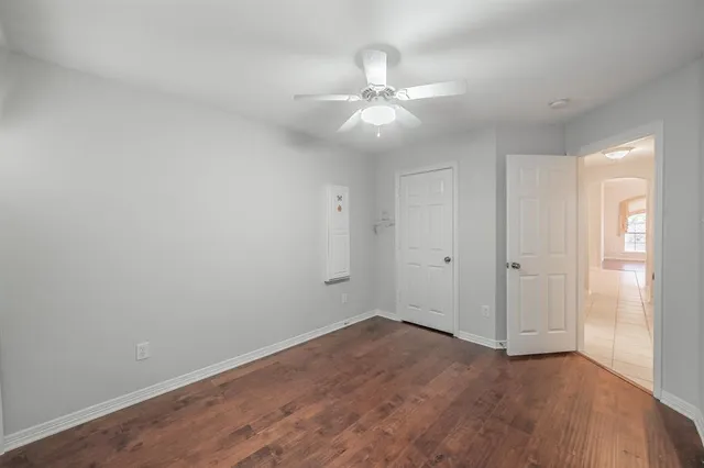 a view of an empty room with wooden floor