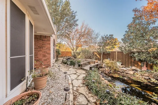 a view of a backyard with chair and potted plants