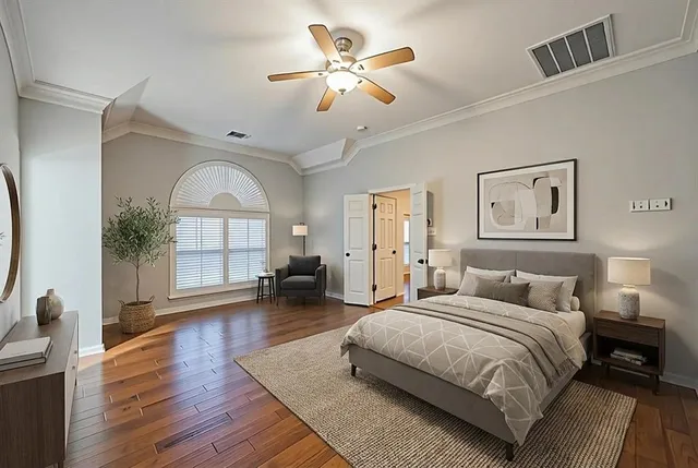 a spacious bedroom with a balcony a bed and a chandelier