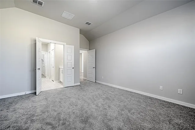 a spacious bathroom with a granite countertop sink a toilet and a mirror