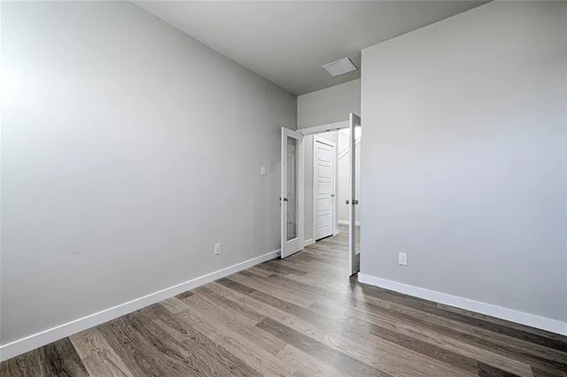 a view of an empty room with wooden floor
