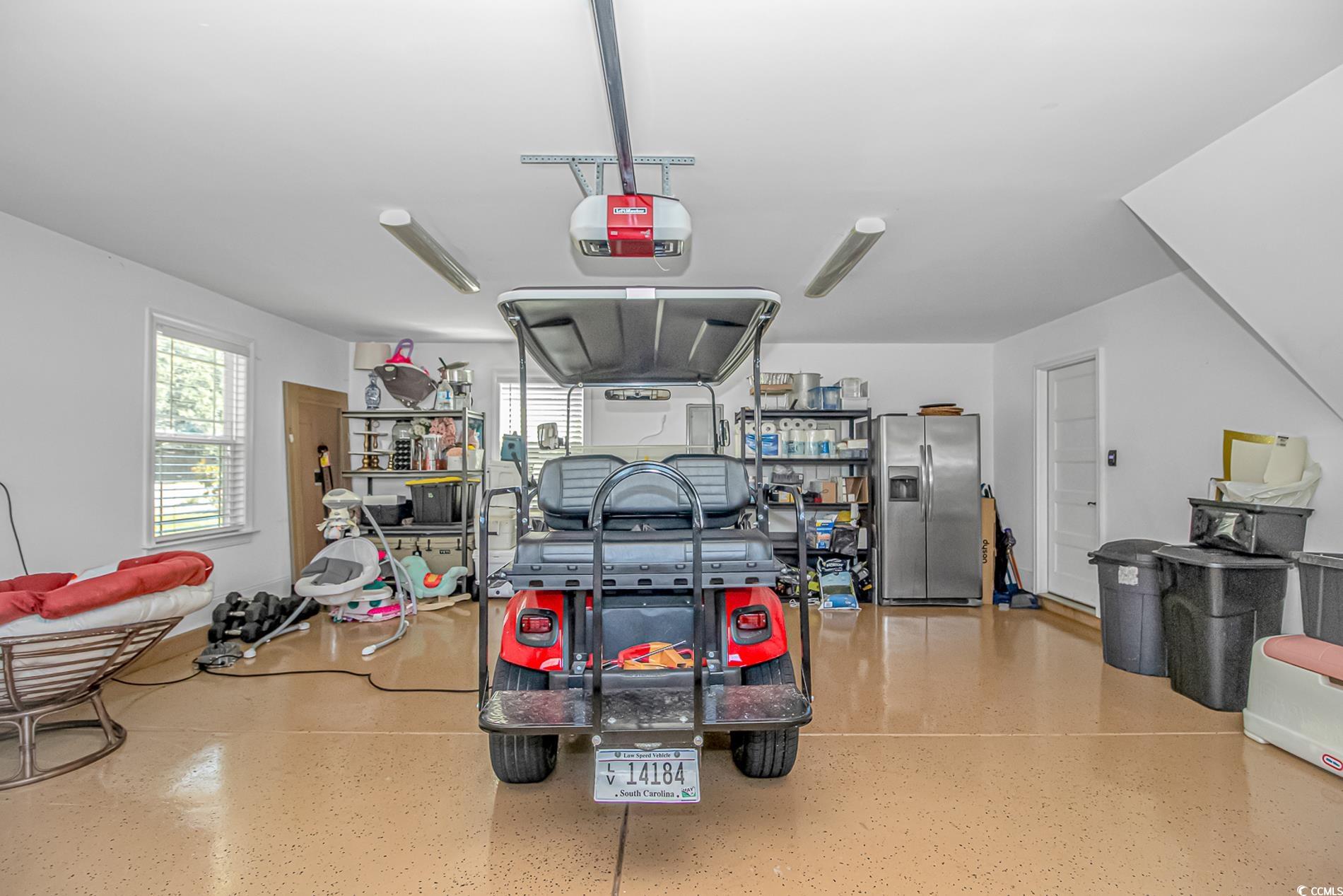 4383 River Road Little River, SC 29566 - Photo 34 of 40 Garage featuring stainless steel fridge with ice dispenser and a garage door opener