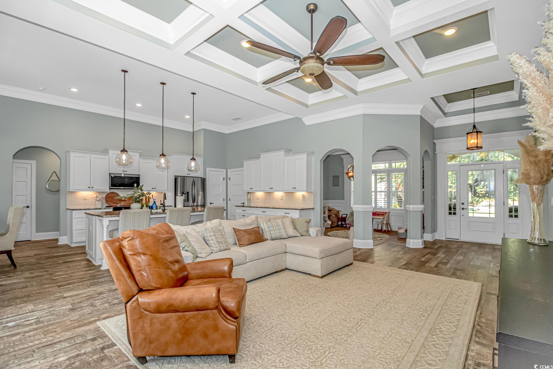 4383 River Road Little River, SC 29566 - Photo 9 of 40 Living room with arched walkways, a towering ceiling, light wood-style floors, coffered ceiling, and beamed ceiling