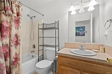 a bathroom with a granite countertop sink toilet a shower and a mirror