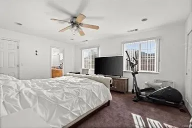 a bedroom with bed tv and window