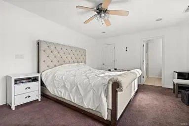 a spacious bedroom with a bed and a chandelier