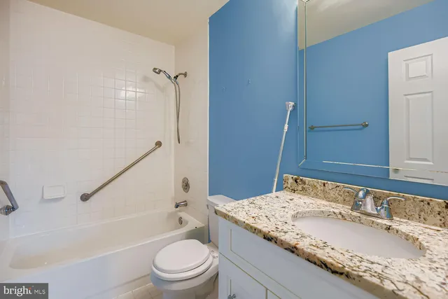 a bathroom with a granite countertop sink toilet and shower