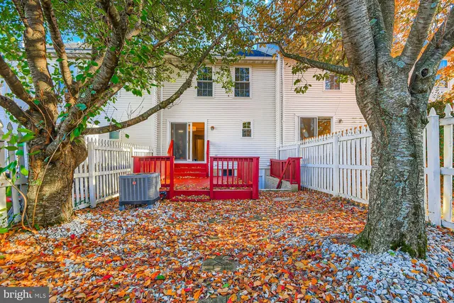 a view of a house with a small yard and wooden fence