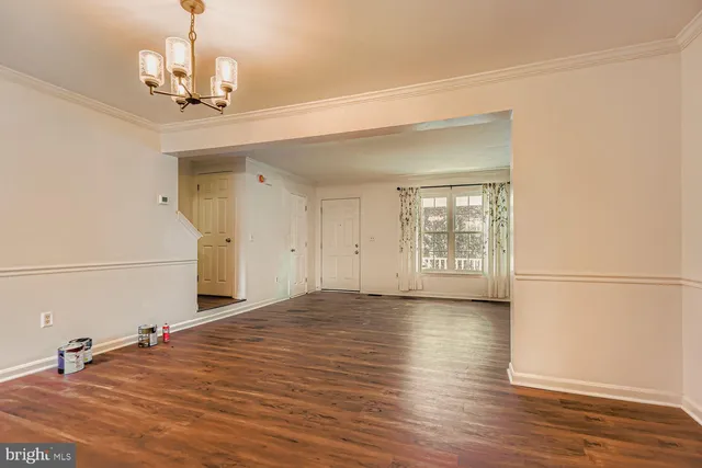 a view of a room with wooden floor and white walls
