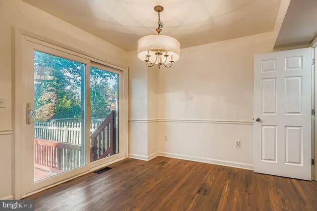 a view of a room with wooden floor fan and windows
