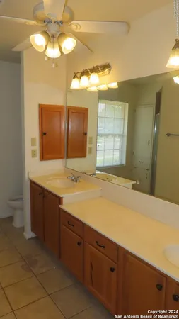 a spacious bathroom with a sink a large mirror and a shower