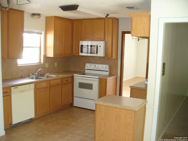 a kitchen with a sink a stove a refrigerator and cabinets