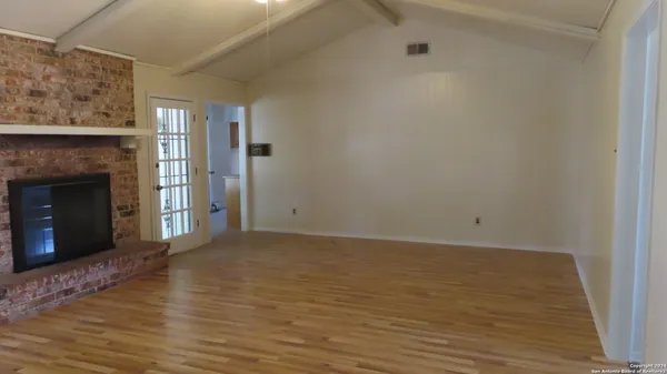 a view of empty room with wooden floor and fireplace