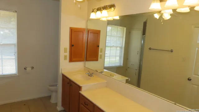a bathroom with a granite countertop sink and a mirror