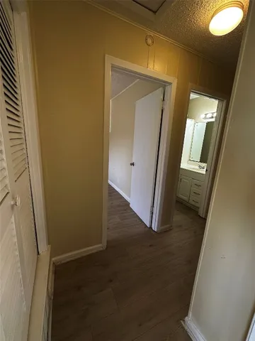 an entryway with wooden floor and a mirror