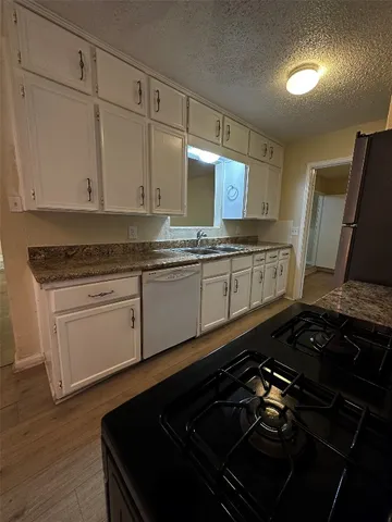 a kitchen with a stove and white cabinets