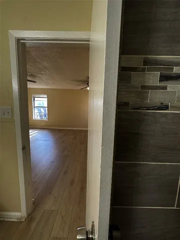 an empty room with wooden floor closet and windows