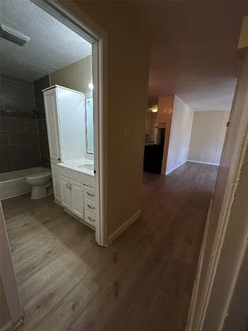 an empty room with wooden floor and mirror