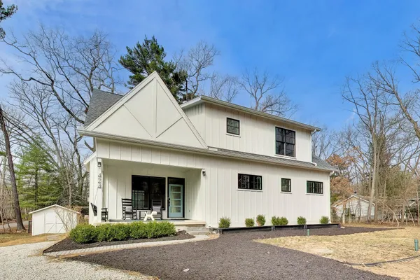 a view of a white house with a large tree