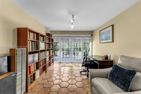 a living room with a couch bookshelf and a window